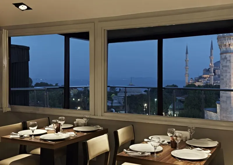 Breakfast tables at dusk, the Blue Mosque and the Sea of Marmara beyond